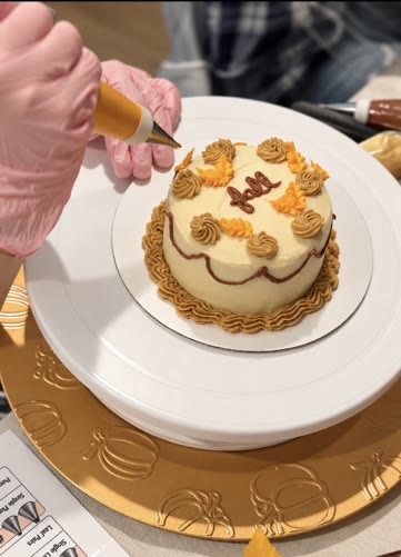 Decorating a small autumn buttercream cake at a LoveLeigh class